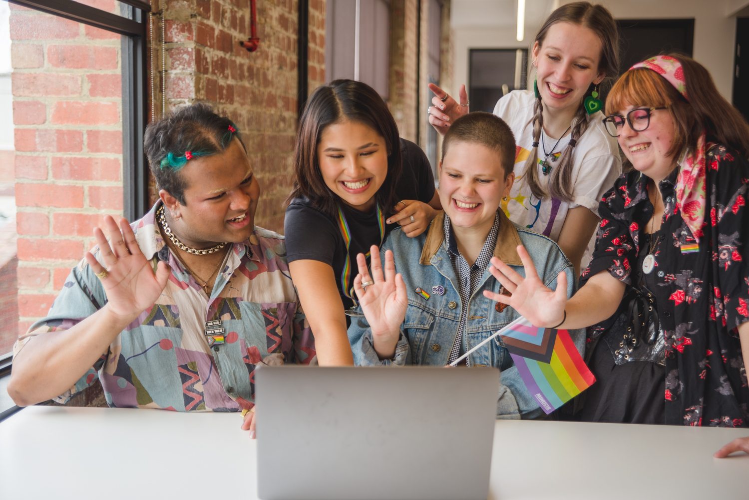 A group of diverse young people looking at a laptop